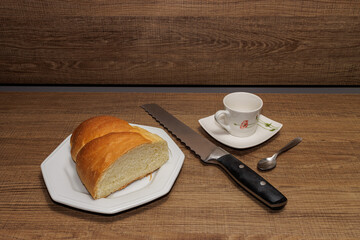 bread, cup, knife and spoon on wood table