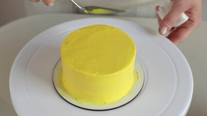 pastry chef levels yellow cream on the cake with cooking spatula close-up