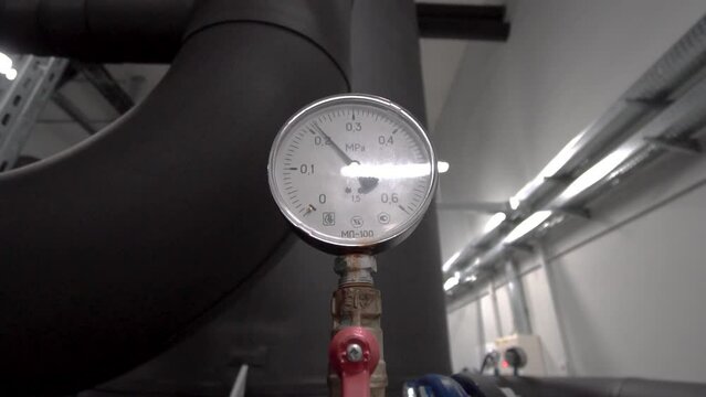 Pressure measuring device with arrow movements near the pipe. Round industrial pressure gauges in a factory. Sensor, Device, System, Mechanism. hd