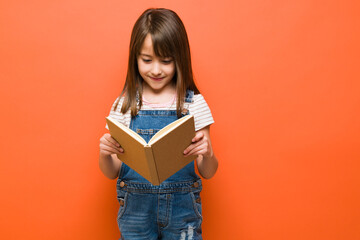 Smart little girl reading a book