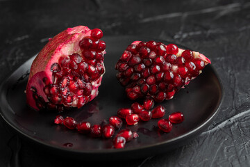 open pomegranate on a dark plate