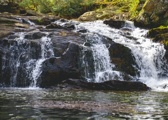 exposed rock waterfall with quick shutter flowing over rocks into river