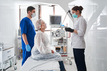 Fototapeta premium Nurse explaining something to the female patient sitting at the hospital bed