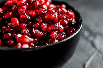 pomegranate seeds in a dark bowl