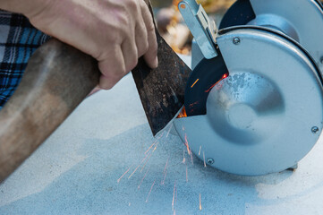 Manual sharpening of an axe using hand tools. Circumcised Hands Of An unknown Person Sharpening An...