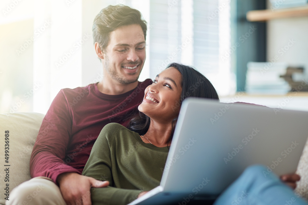 Poster I think its ready to be posted. Shot of an affectionate young couple using their laptop while sitting on the sofa at home.