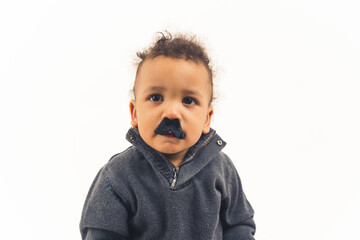 Portrait of an adorable grumpy child in fake mustache wearing gray sweater and looking at camera. Studio shot with white background. High quality photo