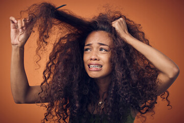 I thought going natural would be less of a struggle. Shot of a woman crying while combing our her...