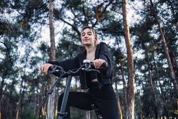 Fototapeta na wymiar young and beautiful woman riding folding bike in the park