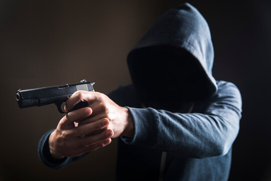 holding a gun on a dark background