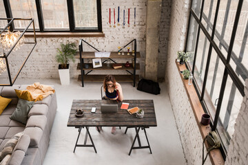 Woman without hand showing her medals at the laptop camera while broadcasting blog