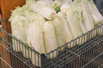 Fresh natural chinese cabbage in trolley, shop basket, vegetables in grocery department of supermarket, store, mall.