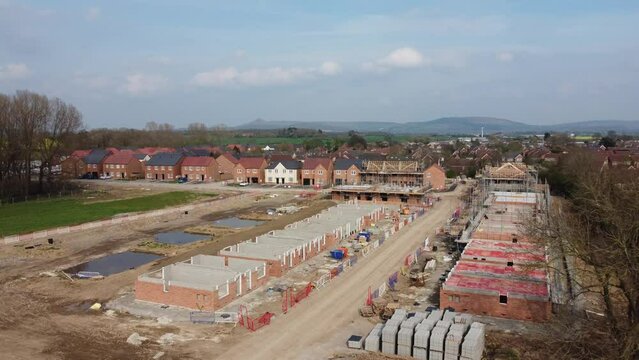 ew UK housing development, showing houses under construction and new builds, in the UK. 4K Arial footage, high quality videography. UK housing project, all stages of construction and development.
