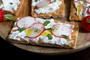 Selective focus. Macro. Healthy toasts with white cheese, radishes and green onions.