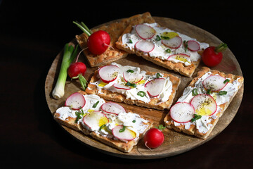 Selective focus. Macro. Healthy toasts with white cheese, radishes and green onions.