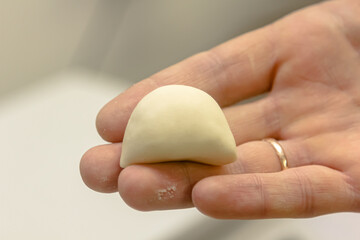 The process of modeling dumplings. Hands in frame.