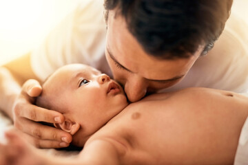 You are loved my little one. Shot of a father bonding with his baby boy at home.