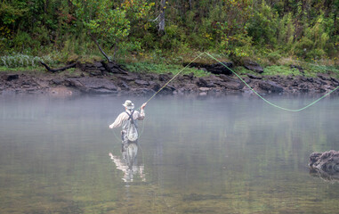 Casting a fly fishing rod in a foggy river