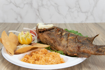Mexican combination meal with fried mojarra fish served with rice and beans for a huge Latino meal