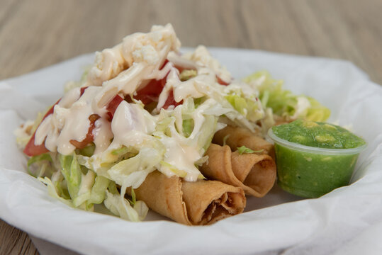 Flour tortilla flautas served in crispy shells and topped with pico de gallo for a delicious Latino flavor