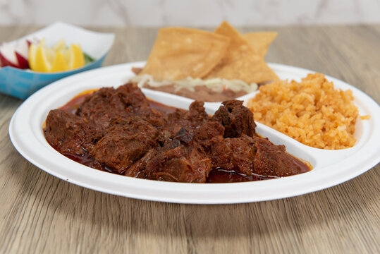 Steak birria stew meat served in gravey with rice and beans as a combination plate