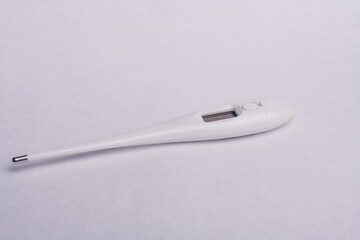 Close up shot of electronic thermometer on white background. Themperature measurment device. Fever, common cold, respiratory infections diagnosis