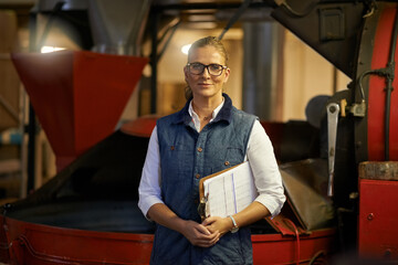 Ive built myself a coffee empire. Portrait of an industrious entrepreneur posing in front of machinery in her coffee roastery.