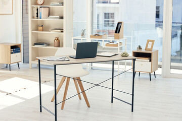 Your workspace is ready for you. Shot of an empty office with a laptop on the table.