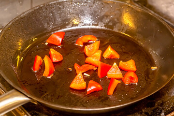 Grilled red pepper in grilling pan on black background