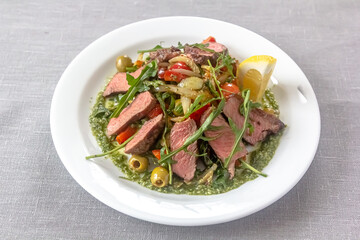 Rare roast beef meal with organic root vegetables