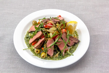 Rare roast beef meal with organic root vegetables