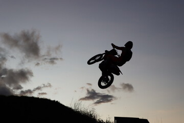 silhouette of motocross rider jumping