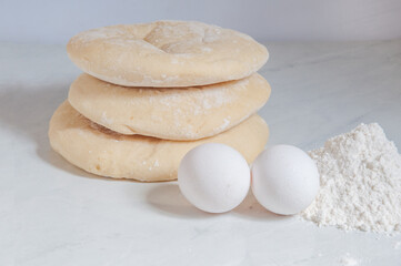 Syrian bread on the table with eggs and flour around
