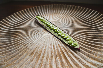 Open Guaje seed pod on a plate with edible seed in Oaxaca, Mexico.