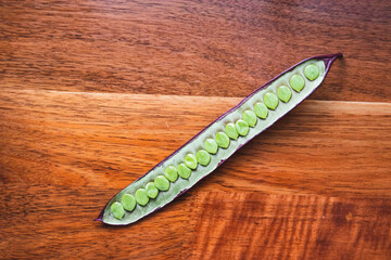 Open Guaje seed pod on a wood table in Oaxaca, Mexico.