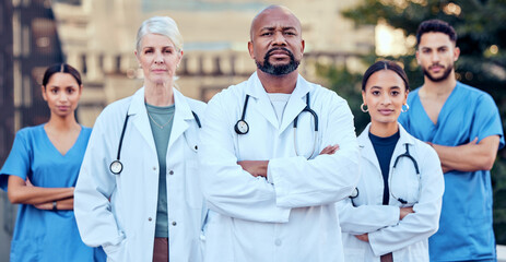 Fototapeta premium Were serious about our work. Shot of a group of doctors standing with their arms crossed in the city.