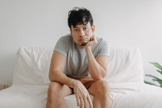 Asian Man Feels Bored With His Boring Life Sit On The Sofa In His Apartment.