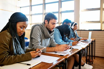 Cellphones are a big distraction. Cropped shot of a group of young university students working in...