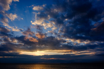 Fototapeta na wymiar 地平線から登る太陽と美しい雲