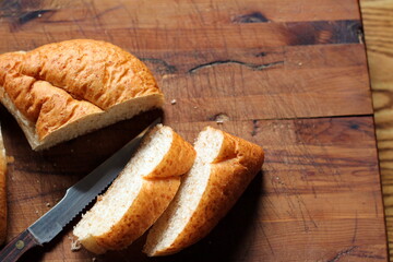 wheat bolilios or freshly baked whole wheat bread to be served Sliced on a wooden cutting board. Photo Flat-lat