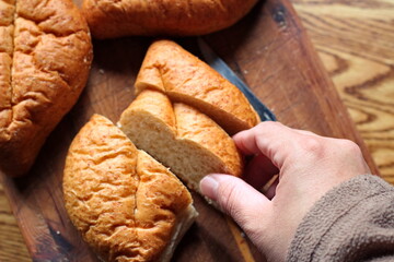 Bread on a wooden cutting board It's a freshly made bread. Photo Flat-lat