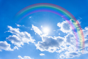 虹のかかった鮮やかな青空と太陽の光