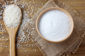 raw organic rice flour in bowl over rustic wooden table