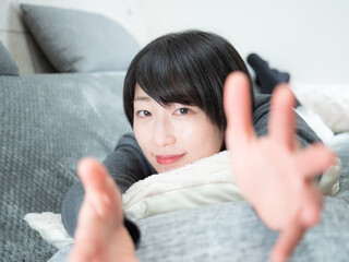 ソファーで寝転ぶ女性