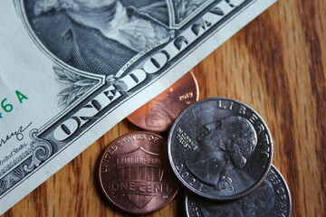 Dollar coins and dollar bills scattered on a wooden table, flat lay dollar coins.