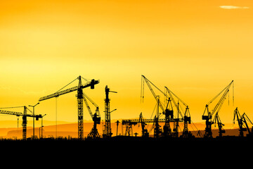 Crane concept in the construction industry. The silhouette of the crane in the construction site
