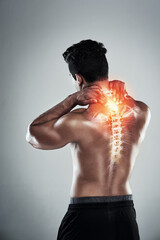 Exercise can do as much harm as good. Rearview shot of a sporty young man holding his neck in pain against a grey background.