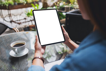 Mockup image of a woman holding digital tablet with blank white desktop screen in the outdoors cafe - obrazy, fototapety, plakaty