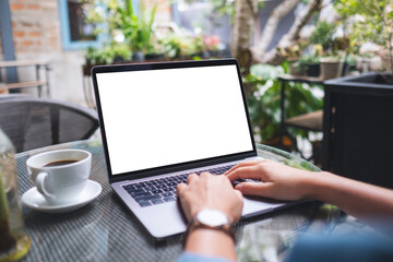 Mockup image of a woman using and working on laptop computer with blank white desktop screen in the outdoors