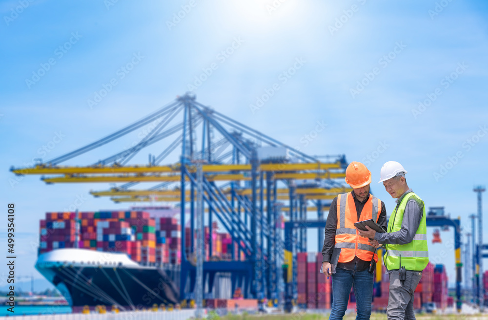Fototapete Engineer wearing uniform inspection and see detail on tablet with logistics container dock cargo yard with working crane bridge in shipyard with transport logistic import export background.